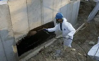 Professional waterproofing the exterior walls of the basement in Lowell, MA