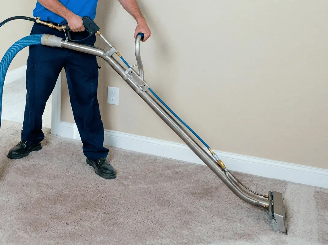 Professional operating a liquid removal machine on a carpeted floor in Lowell, MA